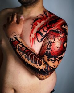 tatuaje en el pecho y tatuaje en el brazo en negro y rojo hecho por abel miranda.